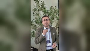 Tıbbi Cihaz Yönetişim Zirvesi 2.0'da Scrap'in Geleceğe Nefes standında zeytin ağaçlarının önünde konuşan İSEK Yönetim Kurulu Üyesi Uğur Mumay
