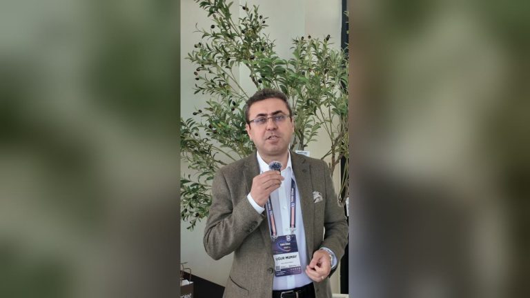 Tıbbi Cihaz Yönetişim Zirvesi 2.0'da Scrap'in Geleceğe Nefes standında zeytin ağaçlarının önünde konuşan İSEK Yönetim Kurulu Üyesi Uğur Mumay